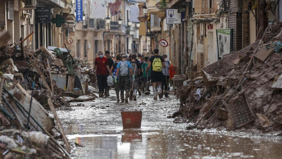 Un grupo de voluntarios en una calle encharcada en Paiporta.