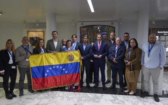 El parlamentario del PNV Mikel Arruabarrena, sosteniendo la bandera de Venezuela, y el lehendakari Pradales, con colectivos de venezolanos en el Parlamento Vasco / Efe El parlamentario del PNV Mikel Arruabarrena, sosteniendo la bandera de Venezuela, y el lehendakari Pradales, con colectivos de venezolanos en el Parlamento Vasco