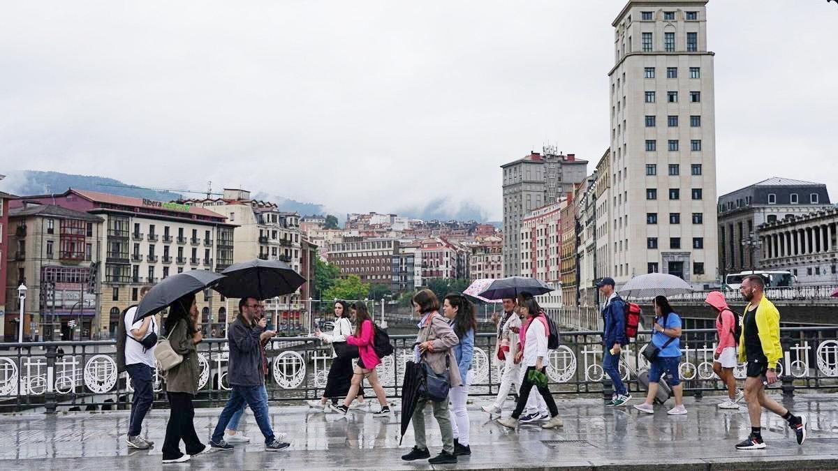Gente paseando por Bilbao en un día de lluvia