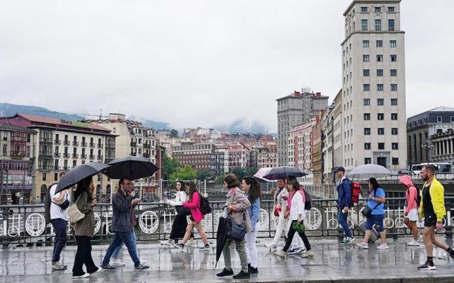 Gente paseando por Bilbao en un día de lluvia