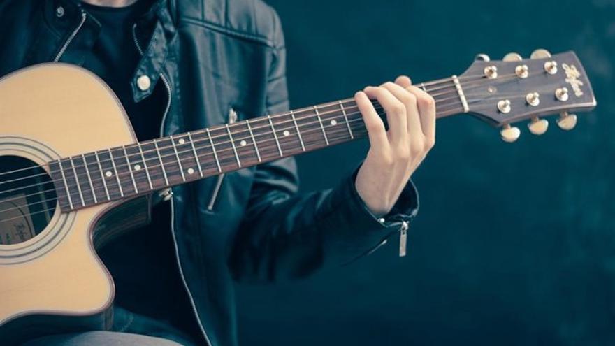 Un hombre toca una guitarra