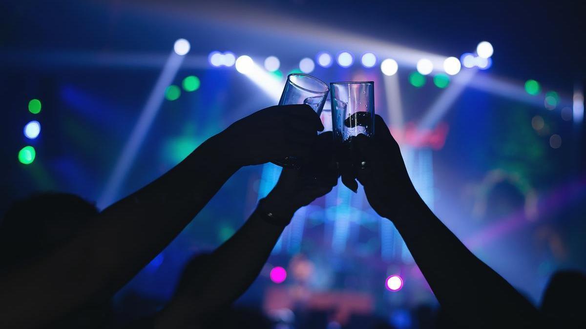 Varios jóvenes beben en una discoteca.