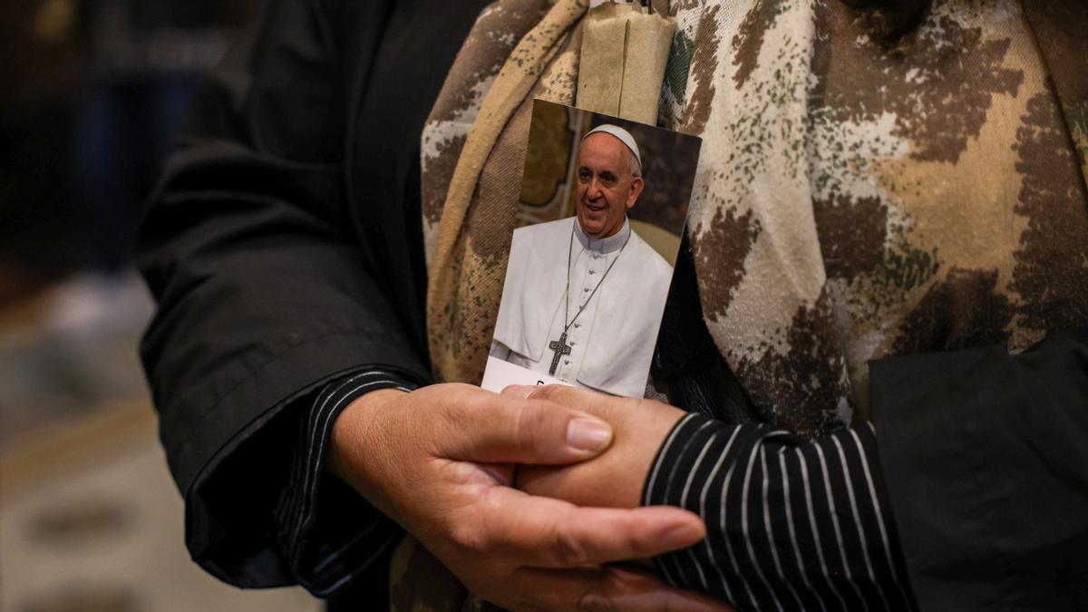 Una mujer sujeta una imagen del fallecido Papa Francisco.