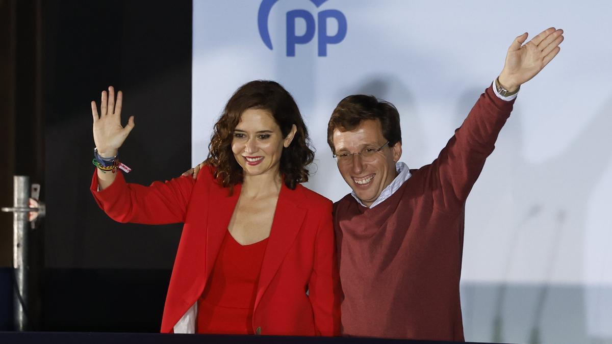 Los candidatos a la presidencia de la Comunidad de Madrid, Isabel Díaz Ayuso y a la alcaldía madrileña, José Luis Martínez-Almeida, saludan desde el balcón de Génova.