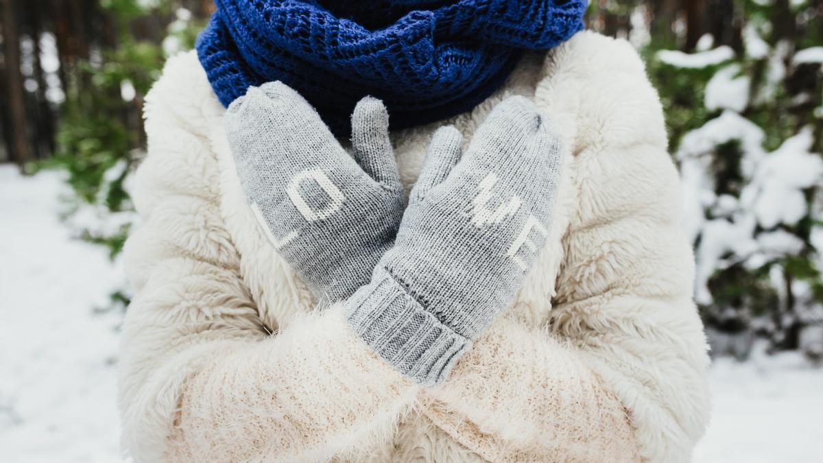 Joven utiliza guantes en la nieve