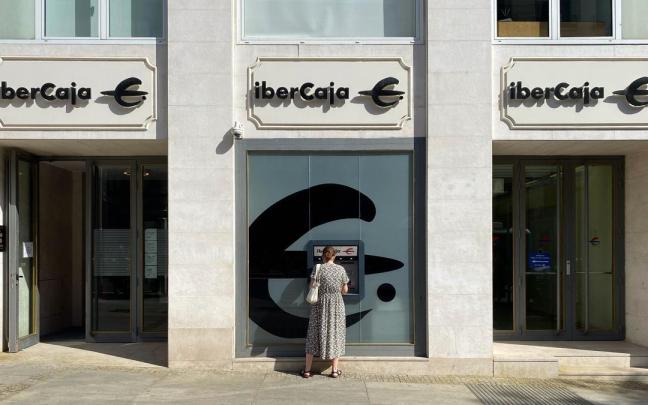 Una mujer saca dinero de una oficina de Ibercaja. Una mujer saca dinero de una oficina de Ibercaja.