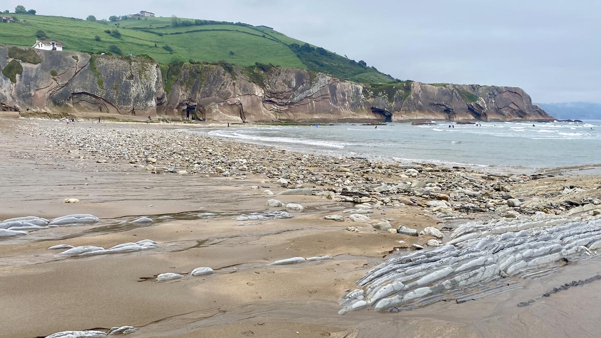 Playa de Itzurun a comienzos de mayo, llena de piedras y las rocas al descubierto.