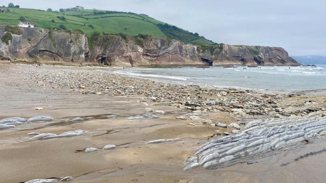 Playa de Itzurun a comienzos de mayo, llena de piedras y las rocas al descubierto.