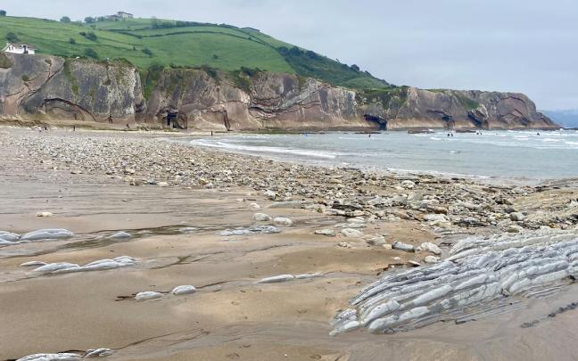 Playa de Itzurun a comienzos de mayo, llena de piedras y las rocas al descubierto.