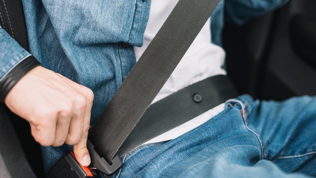 Una persona se coloca el cinturón de seguridad en su coche.