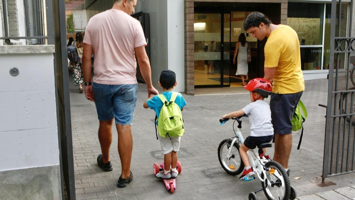 Padres llevan a sus hijos a un centro educativo en el primer día de la vuelta al cole.