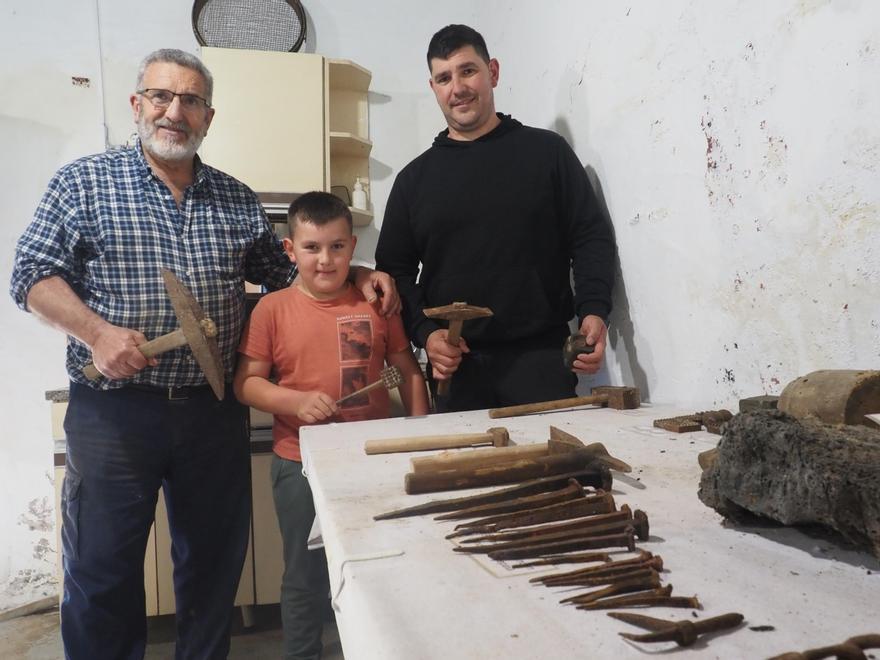 Tres generaciones de la familia Orbegozo, sujetando algunas de las herramientas utilizadas en la ferrería de Egurbide, que se asentaba junto al molino