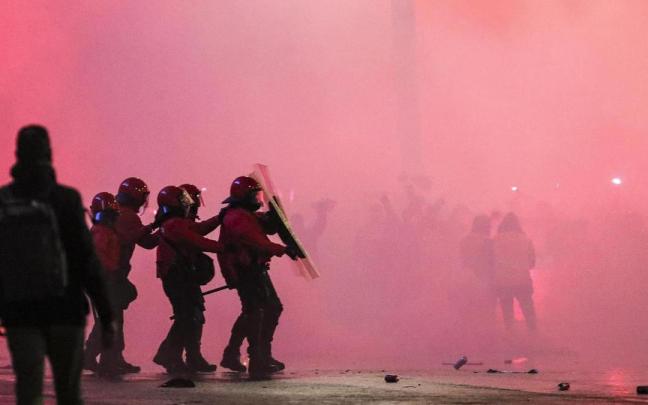 Varios agentes de la Ertzaintza se protegen ante el lanzamiento de objetos en la entrada de San Mamés.