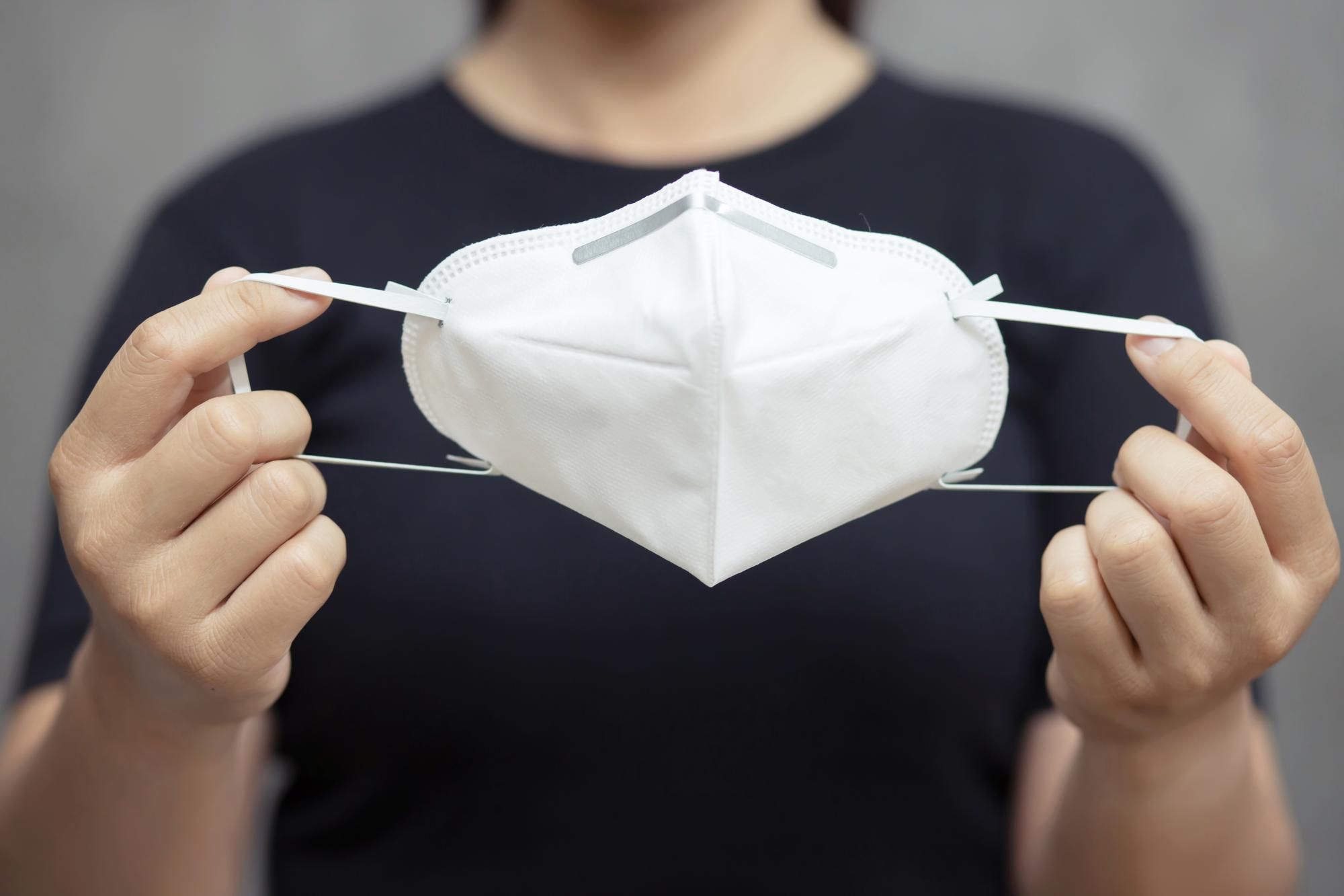 Un hombre muestra una mascarilla FFP2.
