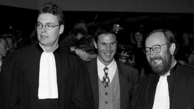 El futbolista belga Bosman sonríe entre sus dos abogados tras ganar el juicio contra la UEFA.