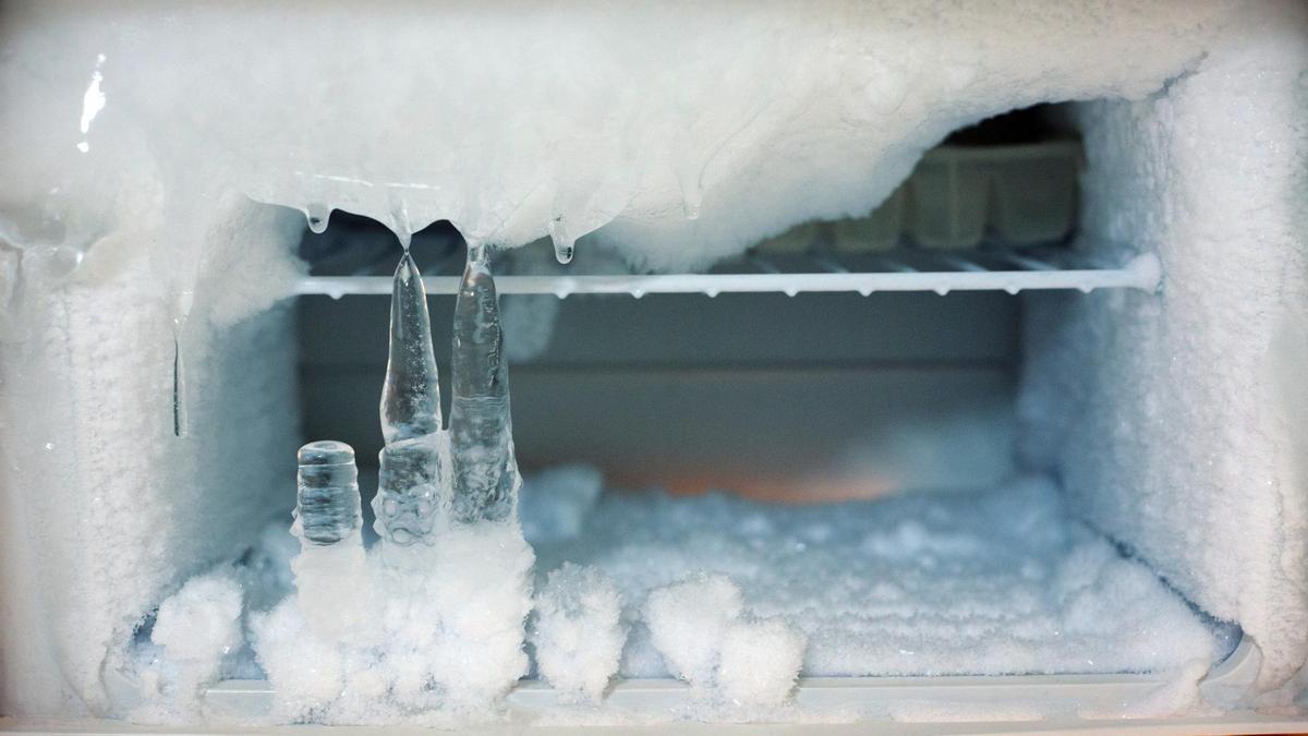 Interior de un congelador con las paredes cubiertas de hielo.