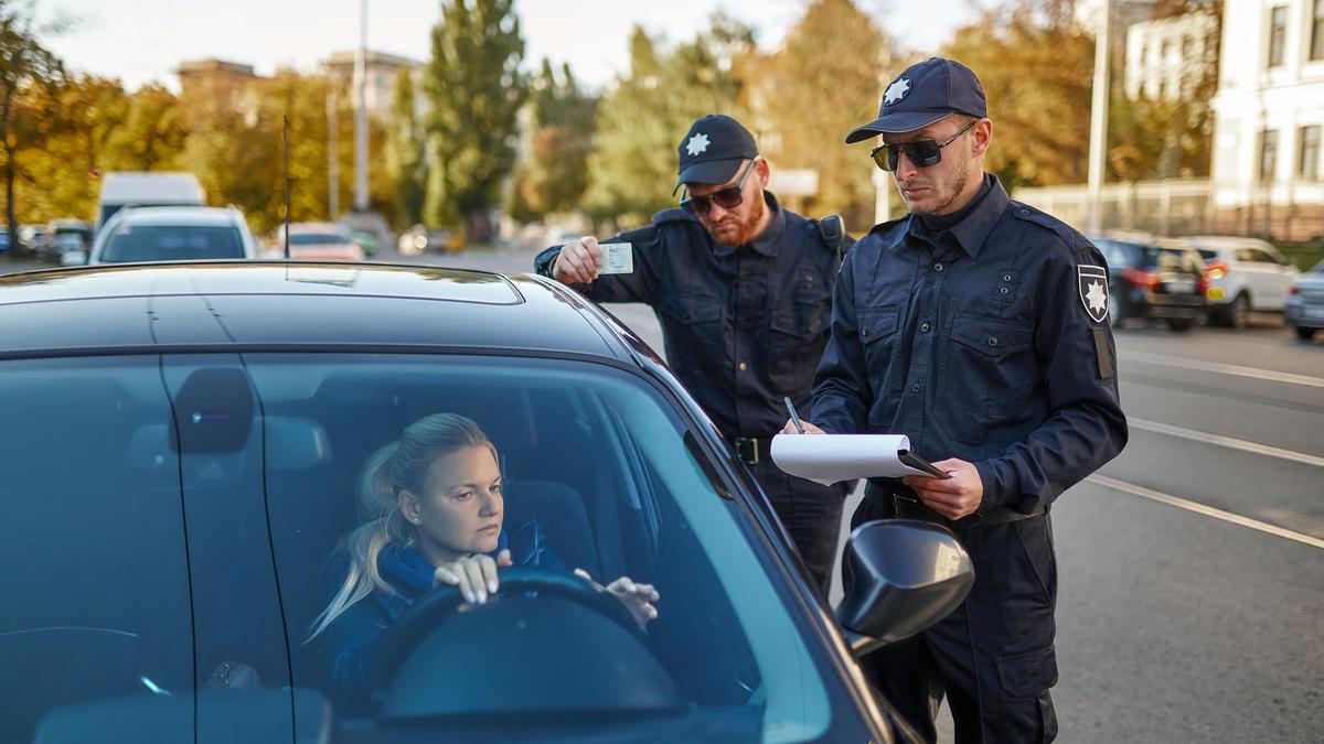 Dos agentes de la policía sancionan a una persona.