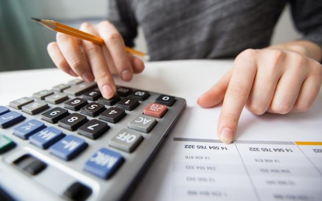 Una persona revisa calculadora en mano las cifras de su nómina. / Freepik Una persona revisa calculadora en mano las cifras de su nómina.