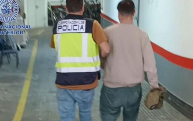Un agente de la Policía Nacional, con el detenido.