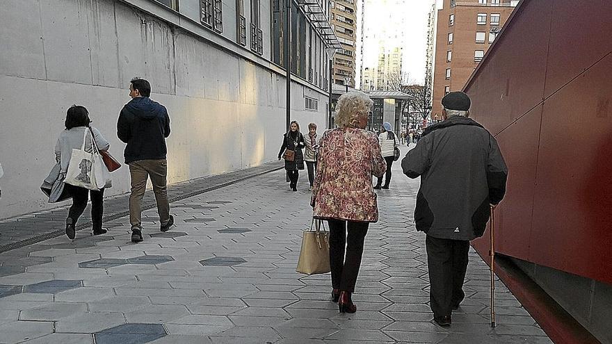 Una pareja de jubilados pasea por la calle. | FOTO: PABLO VIÑAS