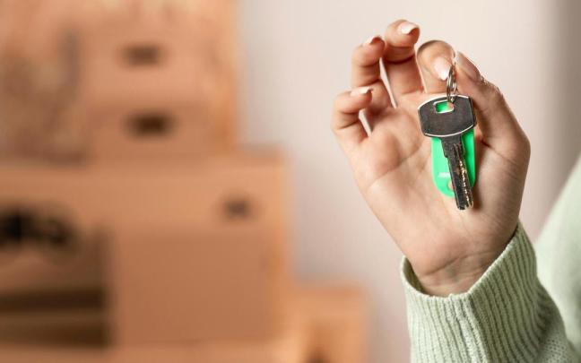 Una mujer sujeta un llavero con una llave.