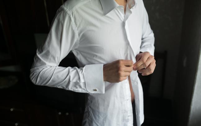 Un hombre poniéndose una camisa. FREEPIK