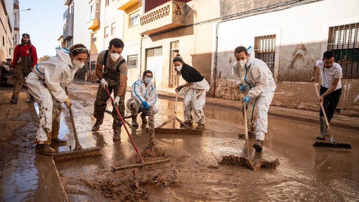 Varias personas realizan tareas de limpieza en una de las zonas afectadas por la DANA.