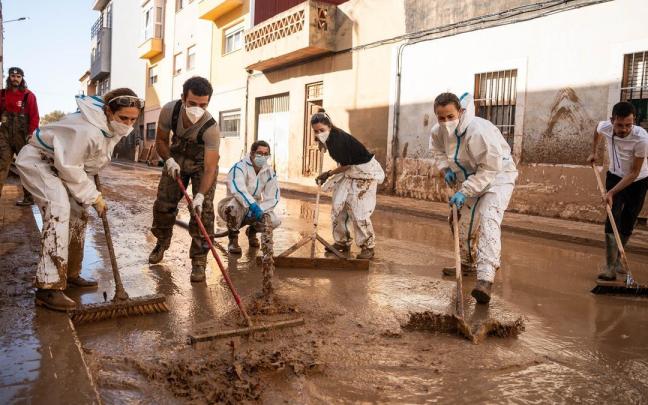 Varias personas realizan tareas de limpieza en una de las zonas afectadas por la DANA.