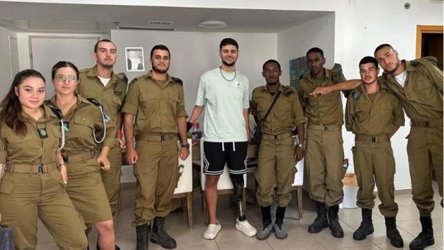 El exsoldado israelí amputado Shalev Biton (en el centro) visita a un grupo de soldados del Ejército israelí.