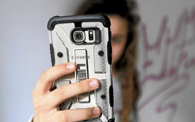 Una menor utiliza un teléfono móvil. Una menor utiliza un teléfono móvil.