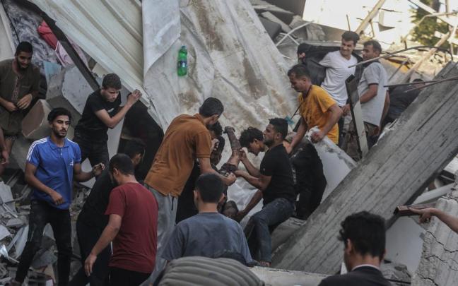 Un grupo de palestinos ayudan a una persona a salir entre los escombros en Gaza.