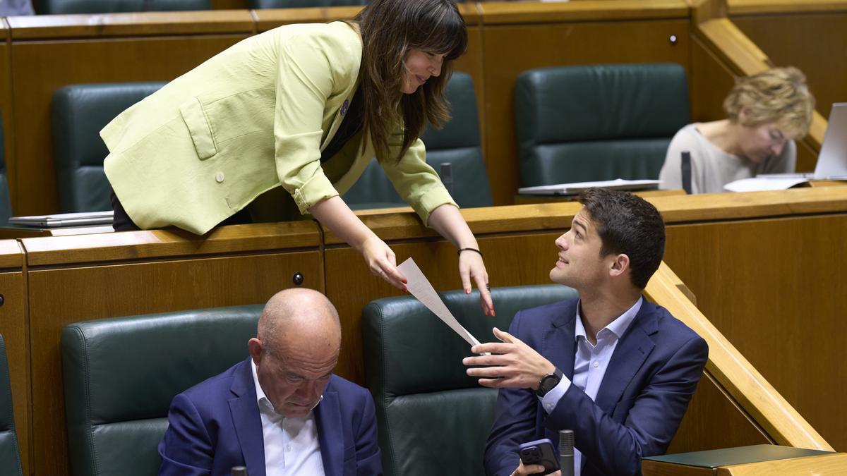 La parlamentaria de EH Bildu Oihana Etxebarrieta entrega un documento al portavoz del PNV, Joseba Díez Antxustegi