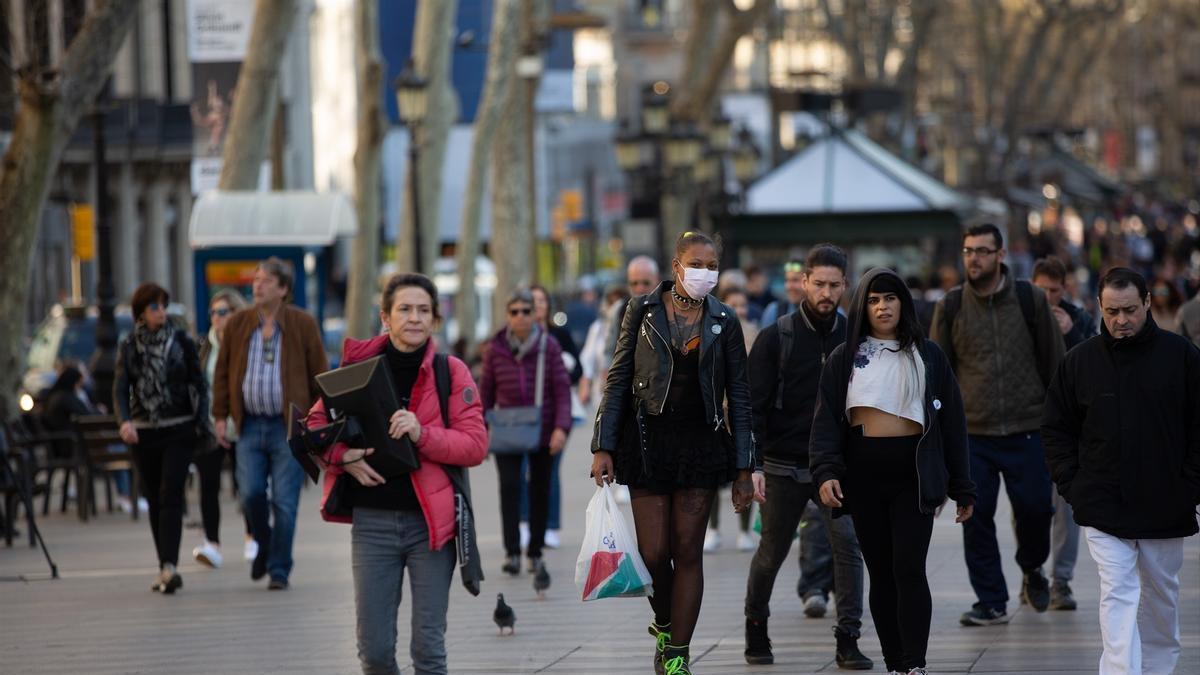 Varias personas caminan por Barcelona.