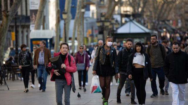 Varias personas caminan por Barcelona.