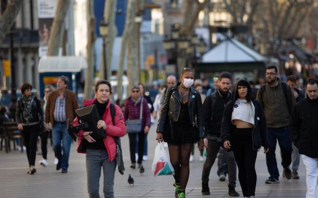 Varias personas caminan por Barcelona.