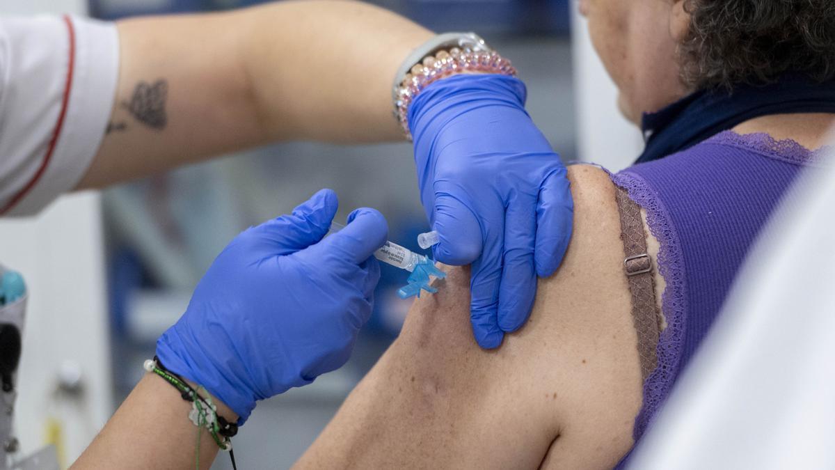 Una profesional sanitaria administra una vacuna a una mujer en una foto de archivo.