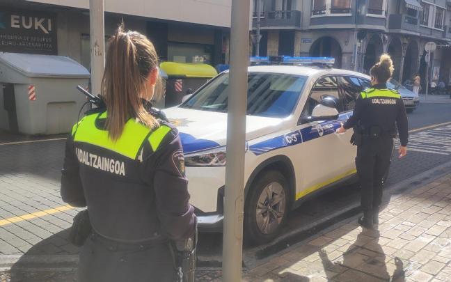 Dos agentes de la Policía Municipal de Eibar accedern al coche patrulla.