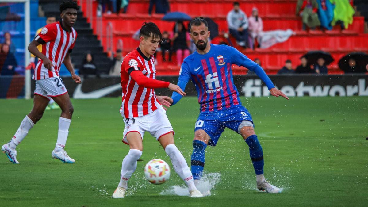 El rojiblanco Chasco protege el balón ante Carnicer.