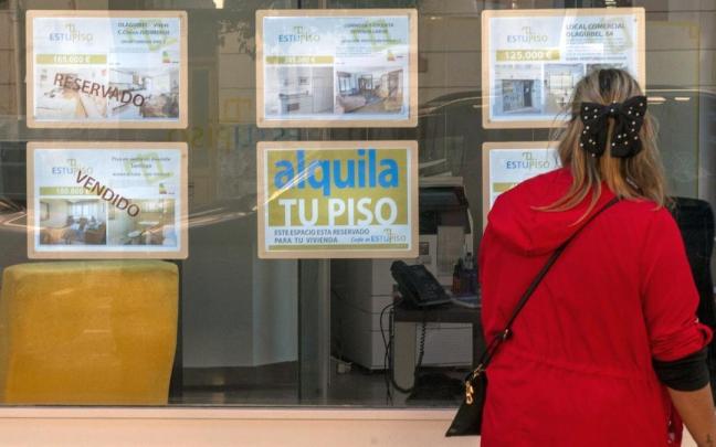 Una mujer mira los anuncios de una inmobiliaria.