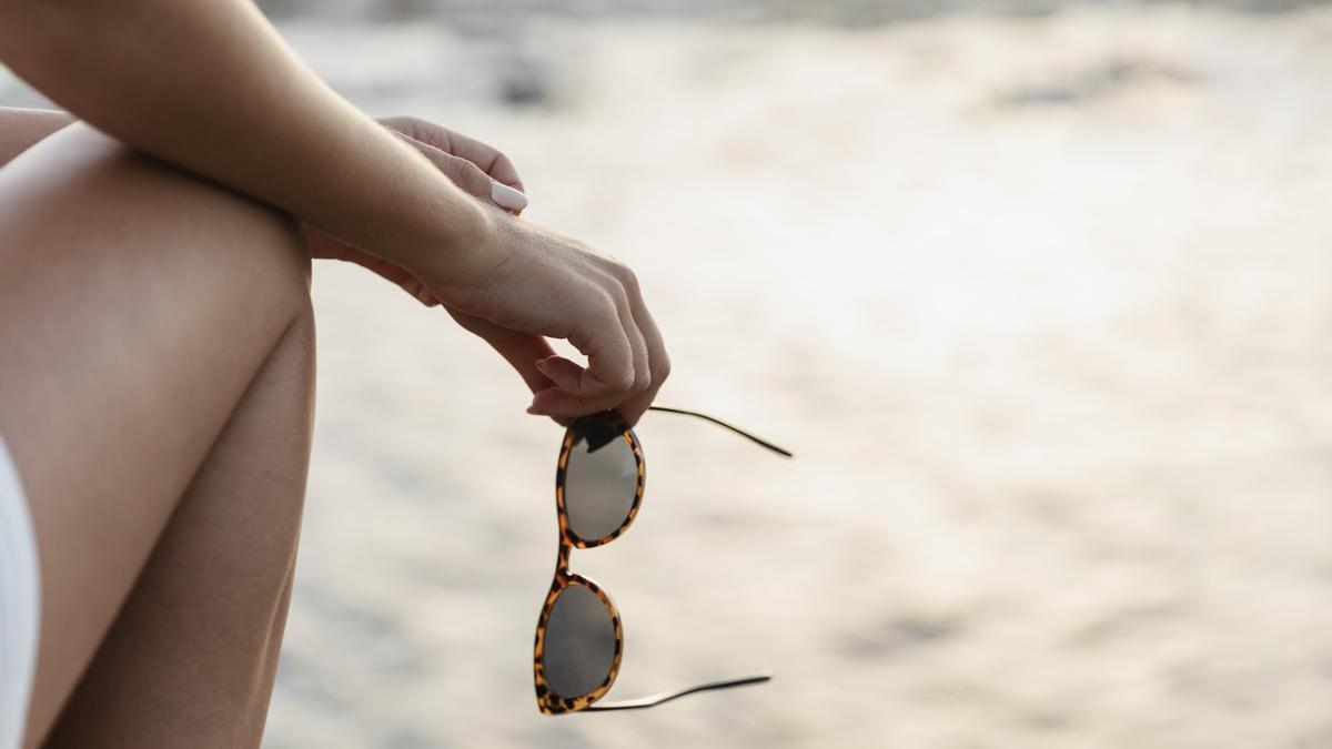 Chica utiliza gafas para protegerse del daño solar en la playa