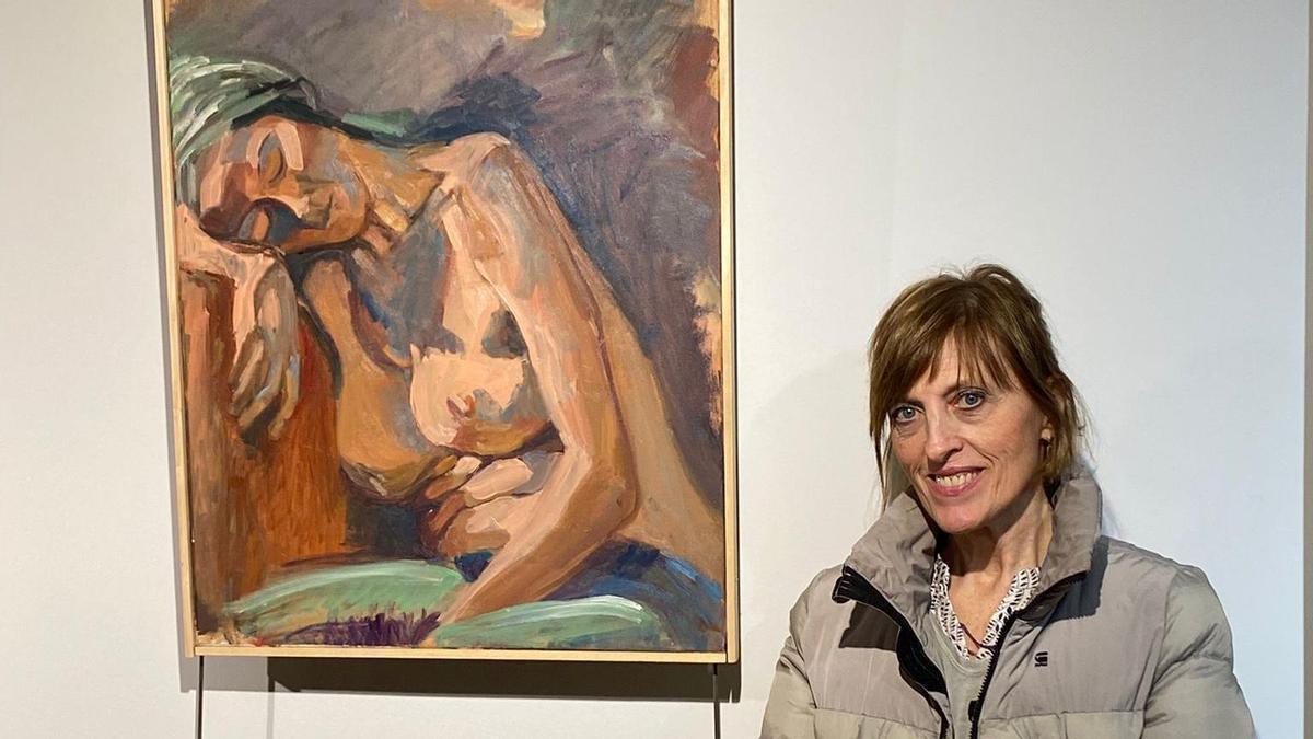 La artista Maite Petralanda posa con uno de los cuadros visibles en su exposición