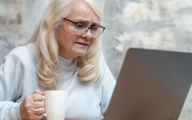 Una mujer trata de entender los pasos para rellenar un formulario digital.