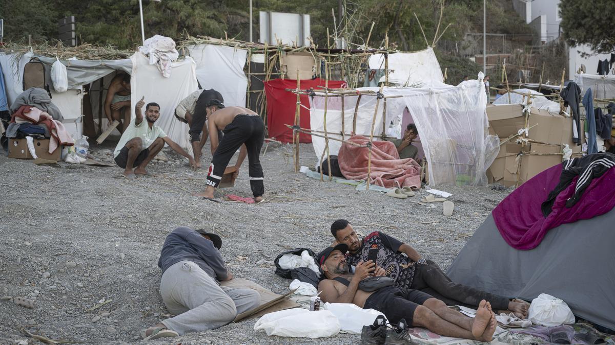 Decenas de personas viven y pernoctan en la playa del Trampolín, a 28 de agosto de 2026, en Ceuta (España). En la zona de la playa del Trampolín permanecen aún cientos de migrantes en situación irregular, donde han vuelto a constr