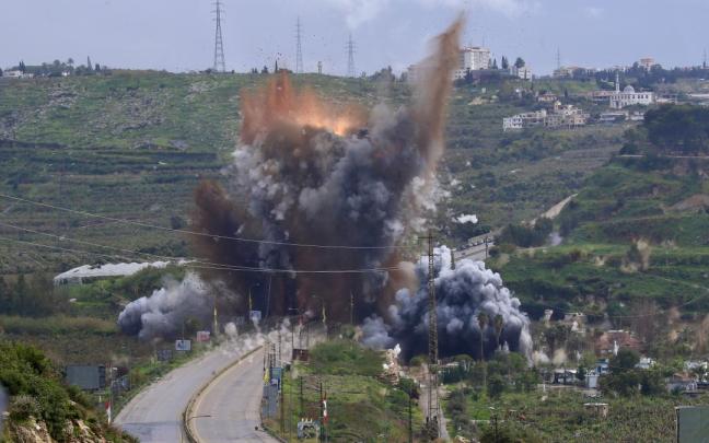 El humo y las llamas se elevan tras un ataque israelí contra el puente de Qasmiya, cerca de Tiro, en el sur del Líbano