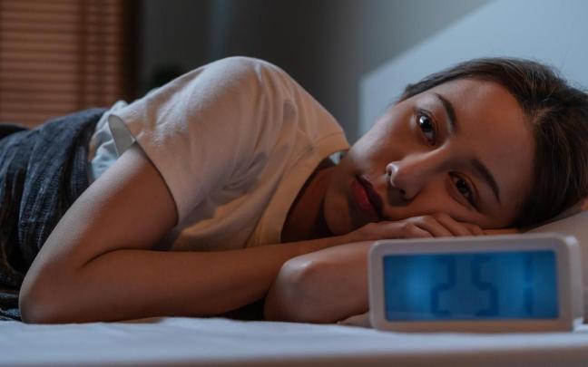 Una mujer despierta de madrugada en la cama. Una mujer despierta de madrugada en la cama.