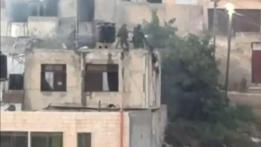 Momento en el que soldados israelíes arrojan uno de los cadáveres.