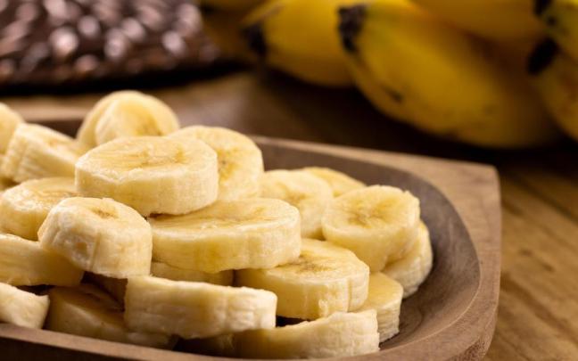 Rodajas de plátano en un recipiente de madera. Rodajas de plátano en un recipiente de madera.