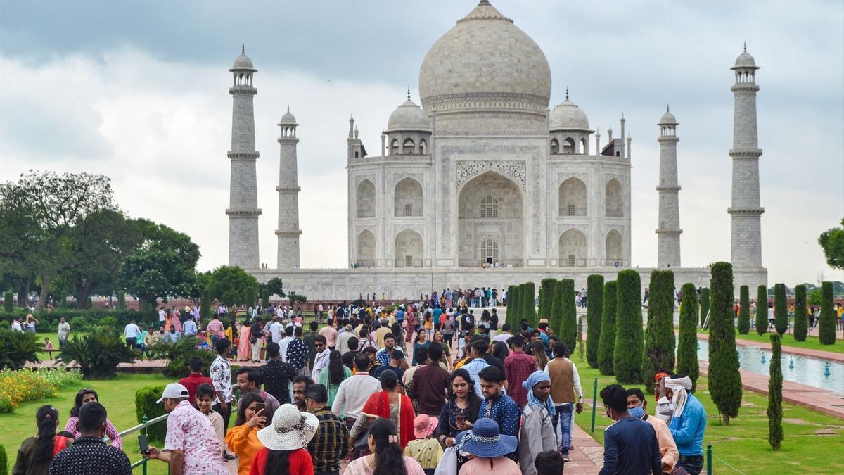 Turistas visitan el histórico Taj Mahal en un día nublado