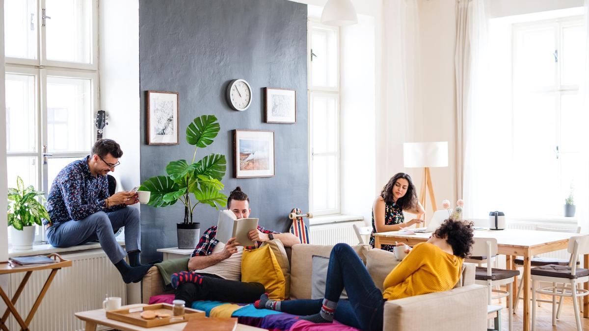 Varias personas comparten una zona común en un coliving.