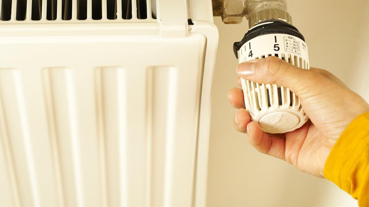 Una persona ajusta la temperatura de su calefacción